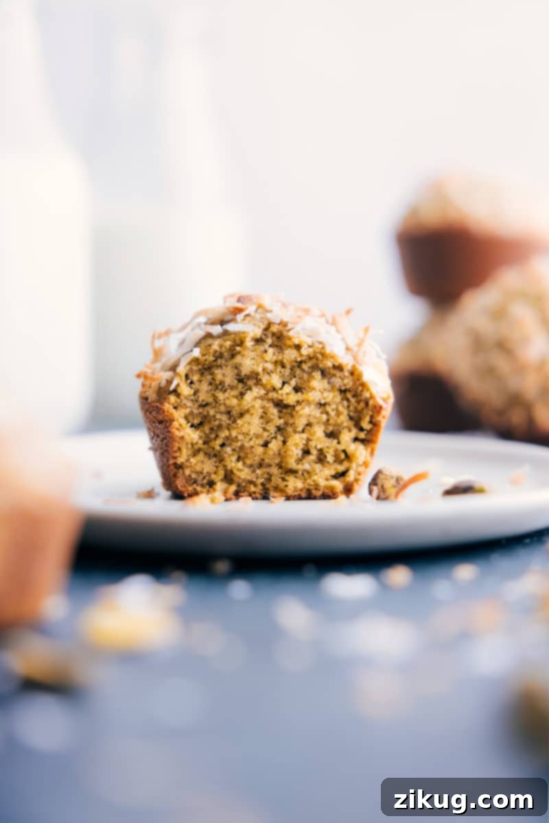 The Best Healthy Pistachio Muffins: Brightly flavored, moist, tender, and perfectly spiced. This quick and easy recipe will become your favorite homemade breakfast or snack. A single perfectly baked Pistachio Muffin on a simple white plate, highlighting its tender texture and inviting green flecks.