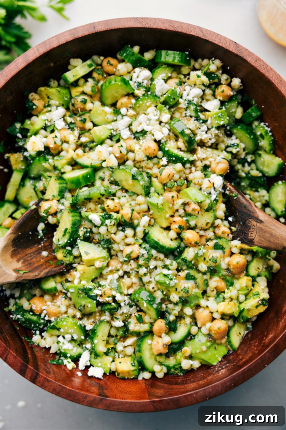 Cucumber feta salad freshly tossed with dressing and ready to be served in a large bowl.