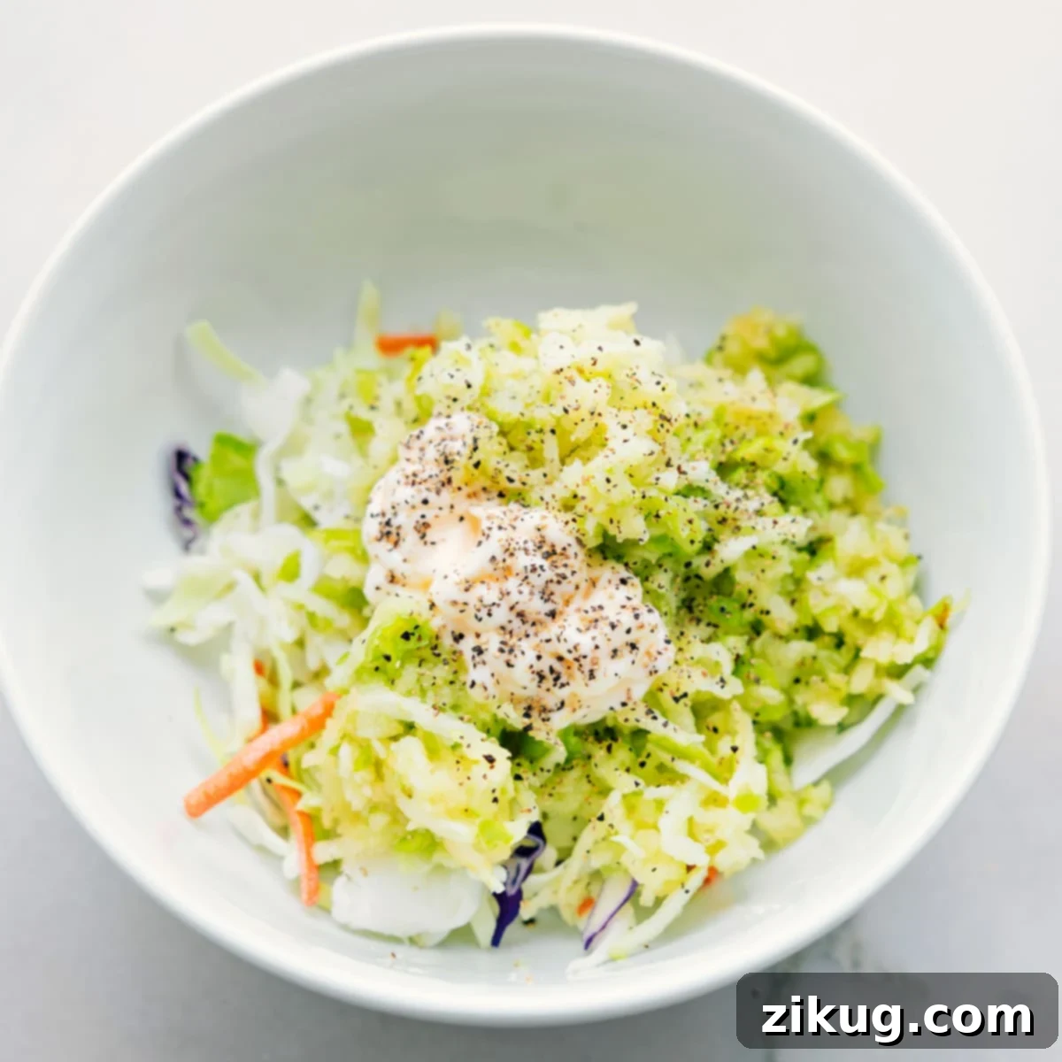 Coleslaw Filling For Healthy Turkey Wraps A bowl filled with the fresh coleslaw mixture ingredients, highlighting the crisp apples and colorful cabbage for the turkey wraps.