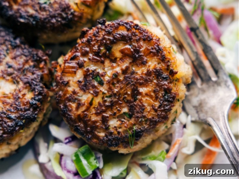 Close up image of a perfectly golden-brown tuna patty showing its crisp exterior and tender interior