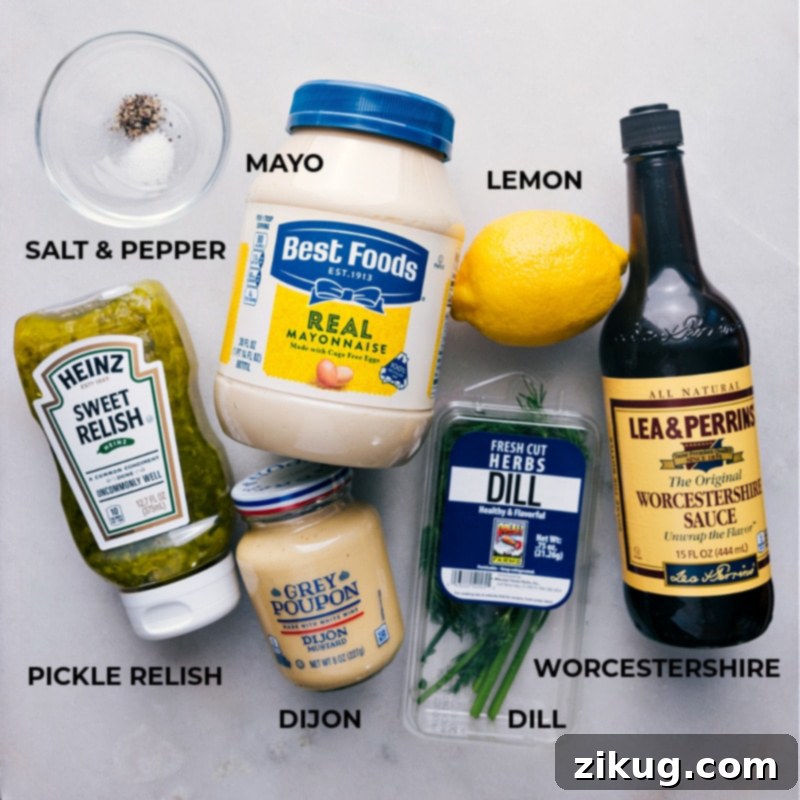 A selection of fresh ingredients laid out for making Tartar Sauce, including a lemon, fresh dill, mayonnaise, and relish.
