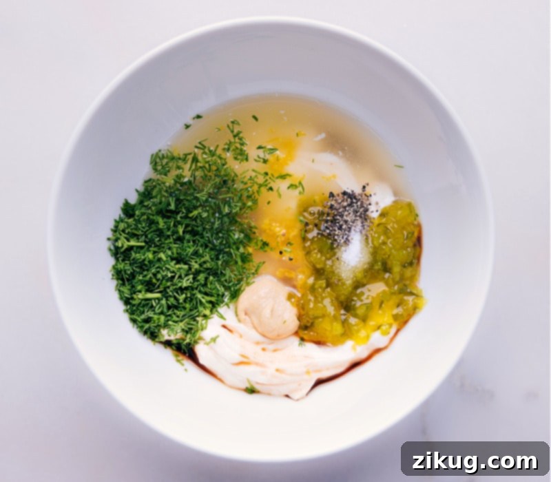 A bowl with all the tartar sauce ingredients mixed together, ready to be chilled and served.