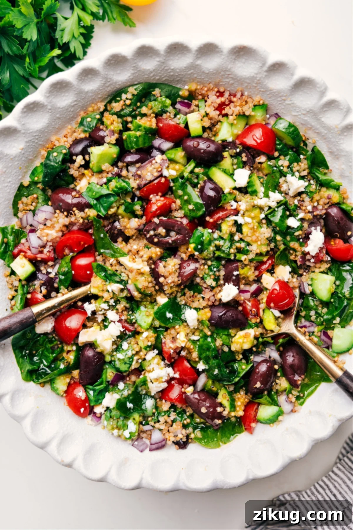 A vibrant Greek quinoa salad in a large bowl, ready to be served, showcasing tender quinoa, crisp cucumbers, ripe tomatoes, and feta.