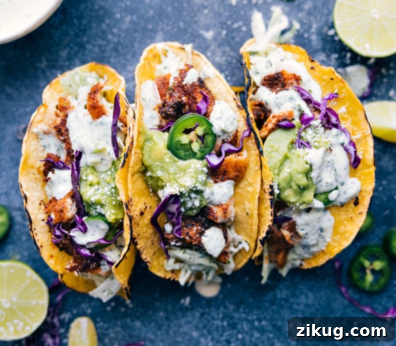 Image of three fully assembled Tilapia Fish Tacos, garnished and ready to eat