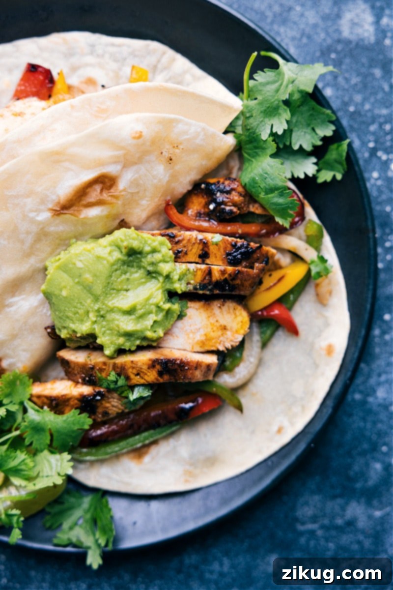 Close-up overhead image of a Chicken Fajita wrapped in a tortilla with toppings