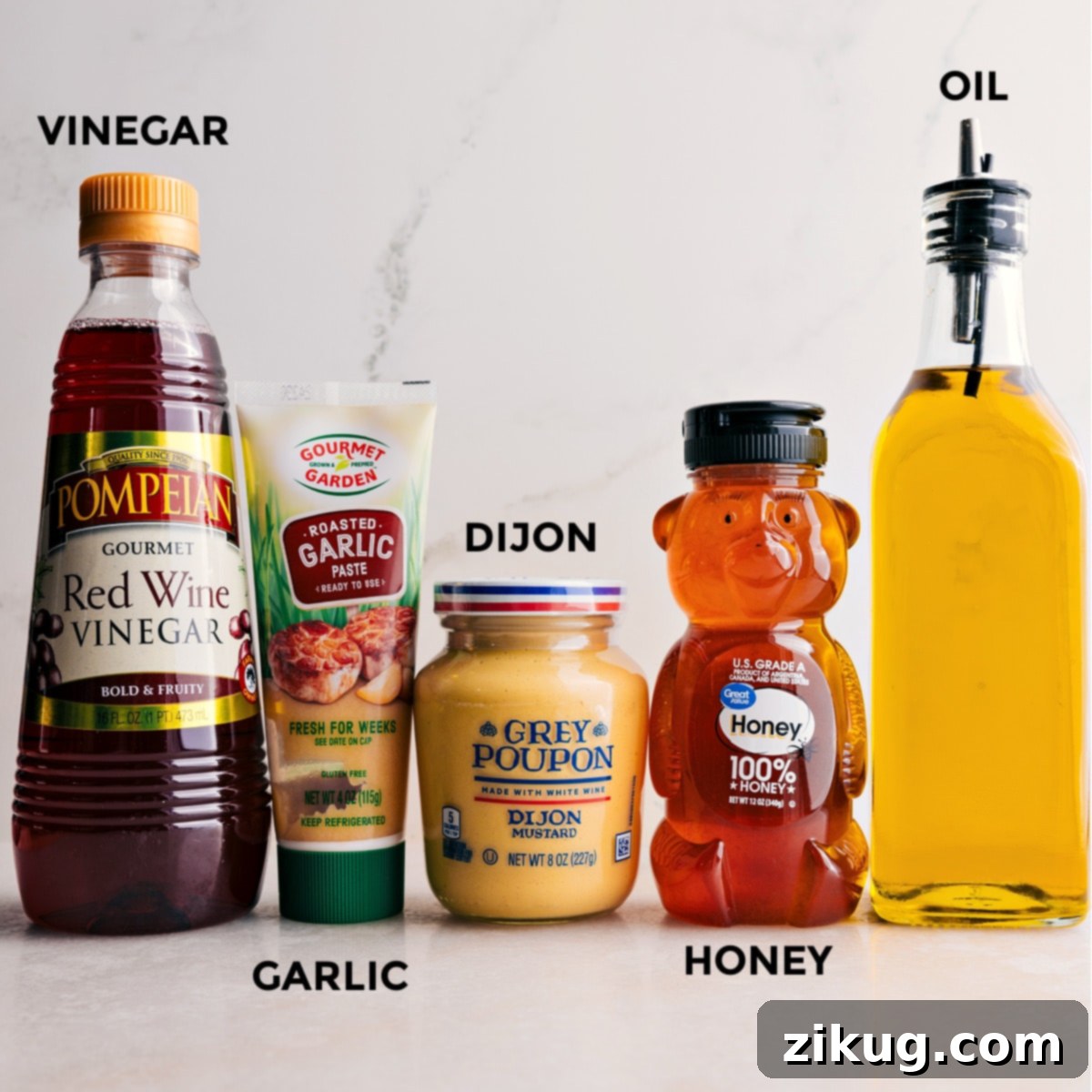 All the ingredients for the quick and simple dressing used in this everyday salad recipe prepped out including honey, oil, dijon mustard, garlic, and red wine vinegar. Components for a vibrant vinaigrette.