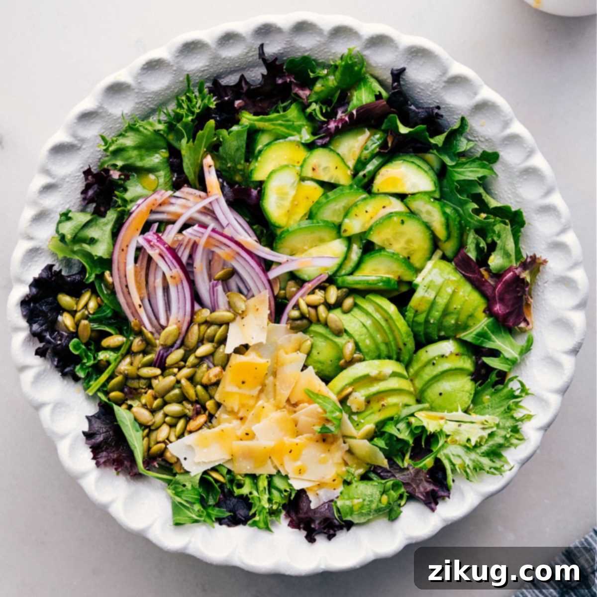 Pour the dressing over the dish. A close-up shot of the fresh salad being dressed.