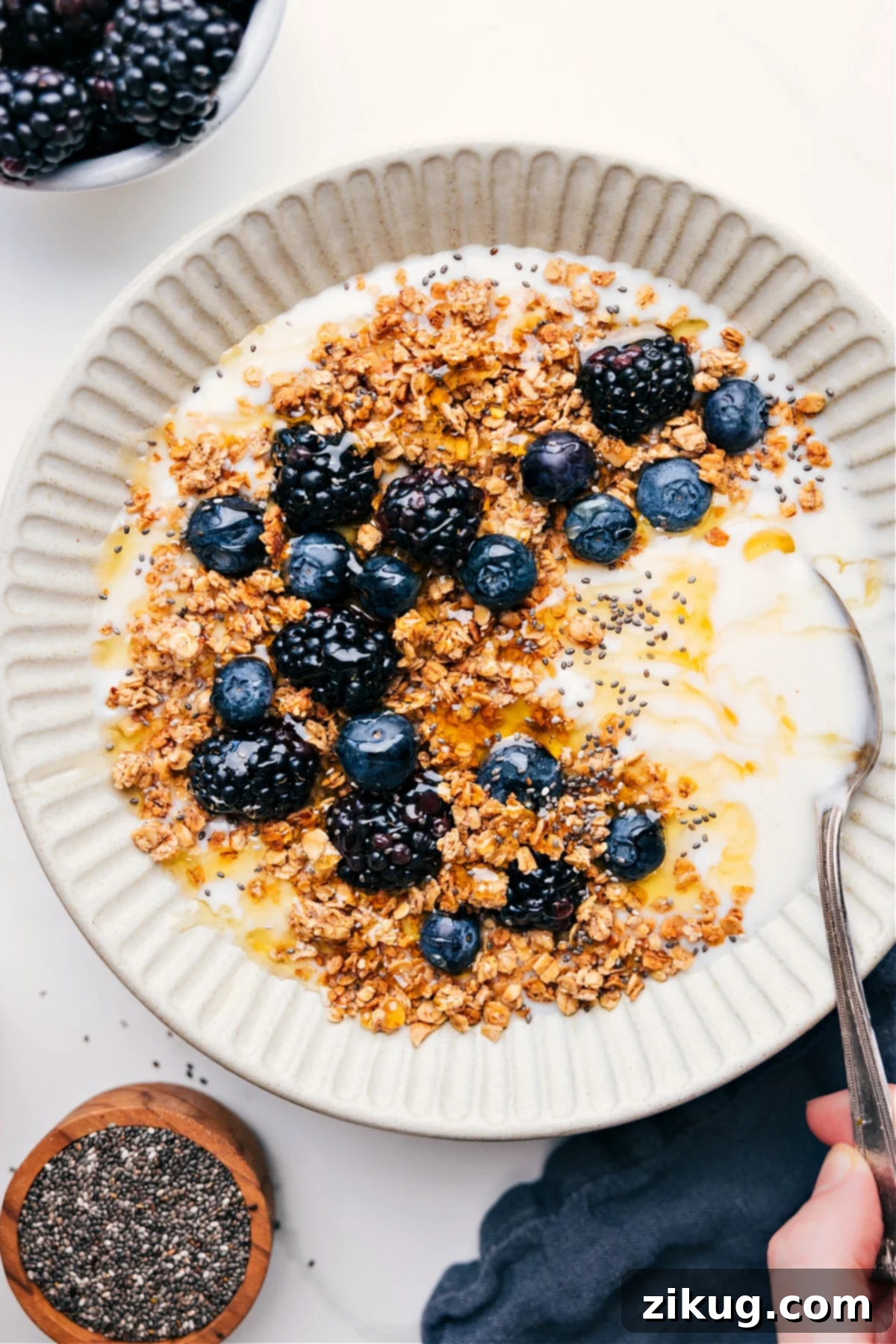 Delicious Homemade Granola Recipe with Yogurt and Berries Easy Homemade Granola Recipe served over creamy yogurt with vibrant fresh berries and a drizzle of honey.