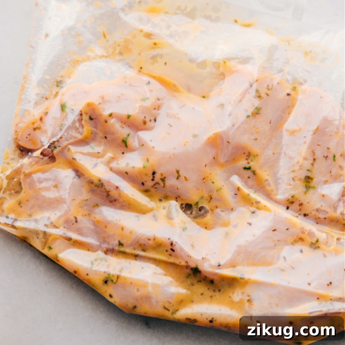 Optimal Marinating Process for Italian Chicken Raw chicken diligently marinating in a rich, flavorful Italian dressing within a secure freezer-size bag, patiently awaiting its transformation into a delicious meal after chilling and cooking.
