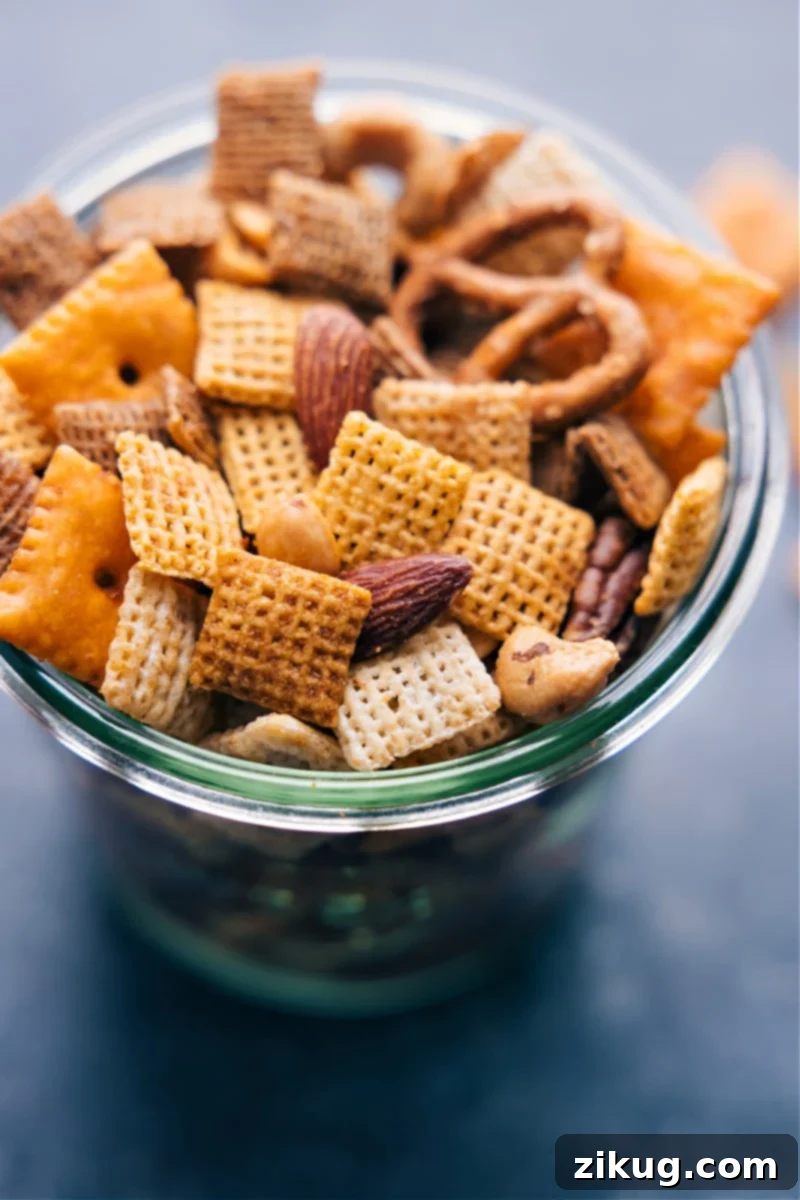 The Ultimate Homemade Chex Mix Recipe: Crispy cereal, pretzels, cheese crackers, and nuts coated in seasoned butter. A truly addicting snack for any occasion! #snackmix #chexmix #chex #snack #cereal #homemade Overhead view of Chex Mix, showcasing its crispy texture and variety of ingredients