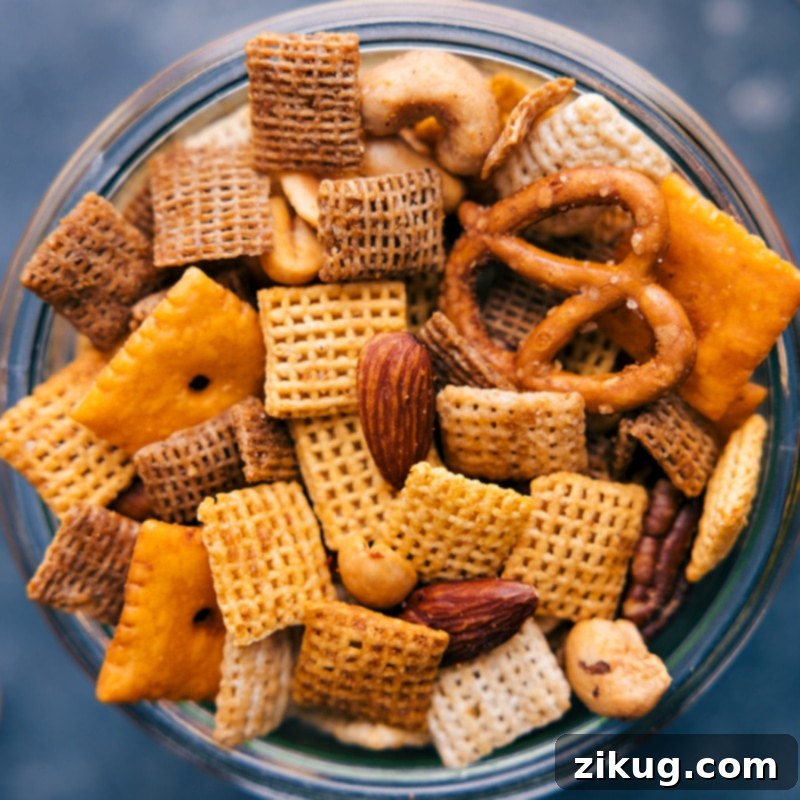 A close-up of the delicious Chex Mix, perfectly coated and ready to enjoy. #addictivesnack #partyfood #savorytreat Close-up view of Chex Mix, showing the crisp coating on each piece