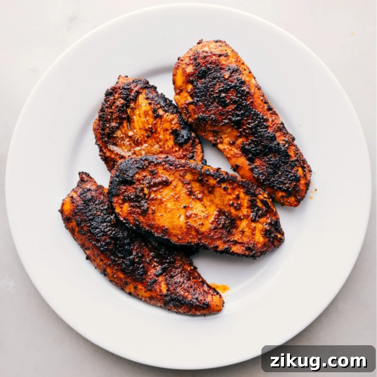 Simple Blackened Chicken Preparation Perfectly cooked blackened chicken, fresh out of the skillet, resting on a plate to allow flavors to meld and juices to redistribute, enhancing its tenderness.