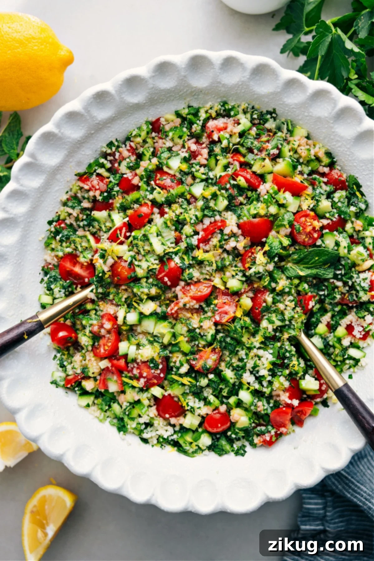A fresh bowl of Tabouli salad, showcasing vibrant green herbs, red tomatoes, and cucumber, ready to be enjoyed.
