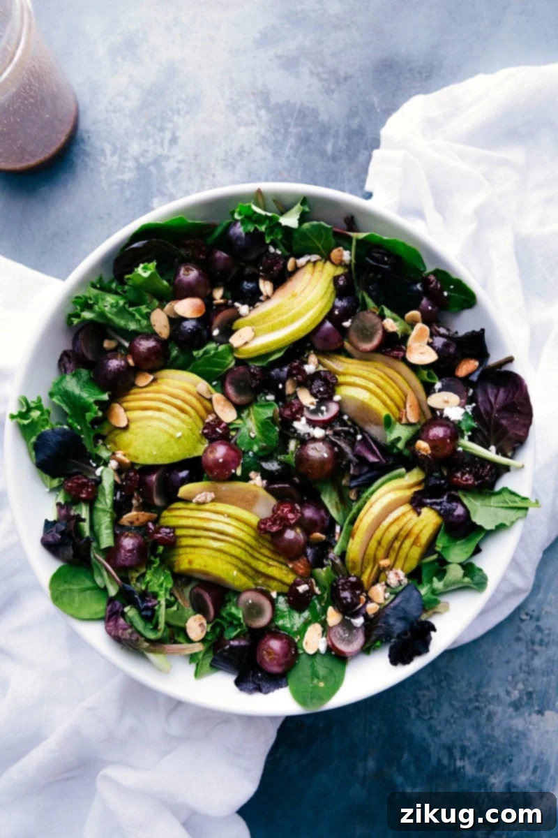 Colorful Fruit Green Salad with Cherry Balsamic Dressing Vibrant pear, grape, and cherry green salad with cherry balsamic dressing on the side, a refreshing delight.