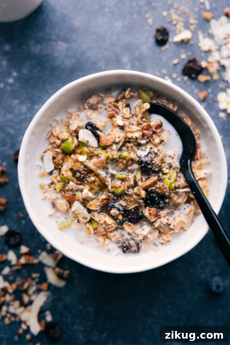 Bircher Muesli is one of my favorite hearty and nutritious breakfast recipes! Loaded with oats, nuts, dried fruit, and plenty of apples -- it's delicious! Recipe via chelseasmessyapron #breakfast #best #quick #easy #simple #healthy #cleaneating #oats #bircher #muesli Overhead image of the Bircher Muesli in a bowl, garnished with fresh fruit and nuts