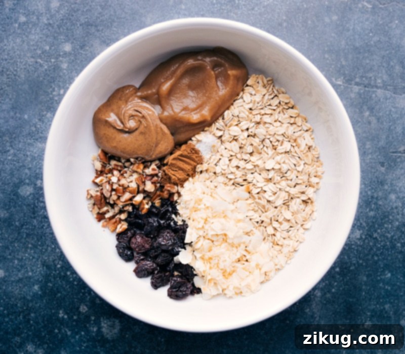 Bircher Muesli is one of my favorite hearty and nutritious breakfast recipes! Loaded with oats, nuts, dried fruit, and plenty of apples! Recipe via chelseasmessyapron #breakfast #best #quick #easy #simple #healthy #cleaneating #oats #bircher #muesli Process shots-- image of most of the ingredients in a bowl ready to be prepared