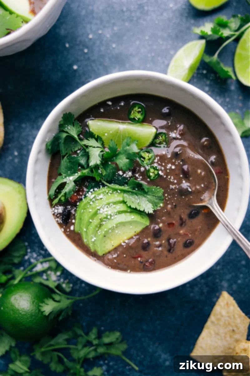 Overhead view of a comforting bowl of Black Bean Soup garnished with fresh cilantro and lime