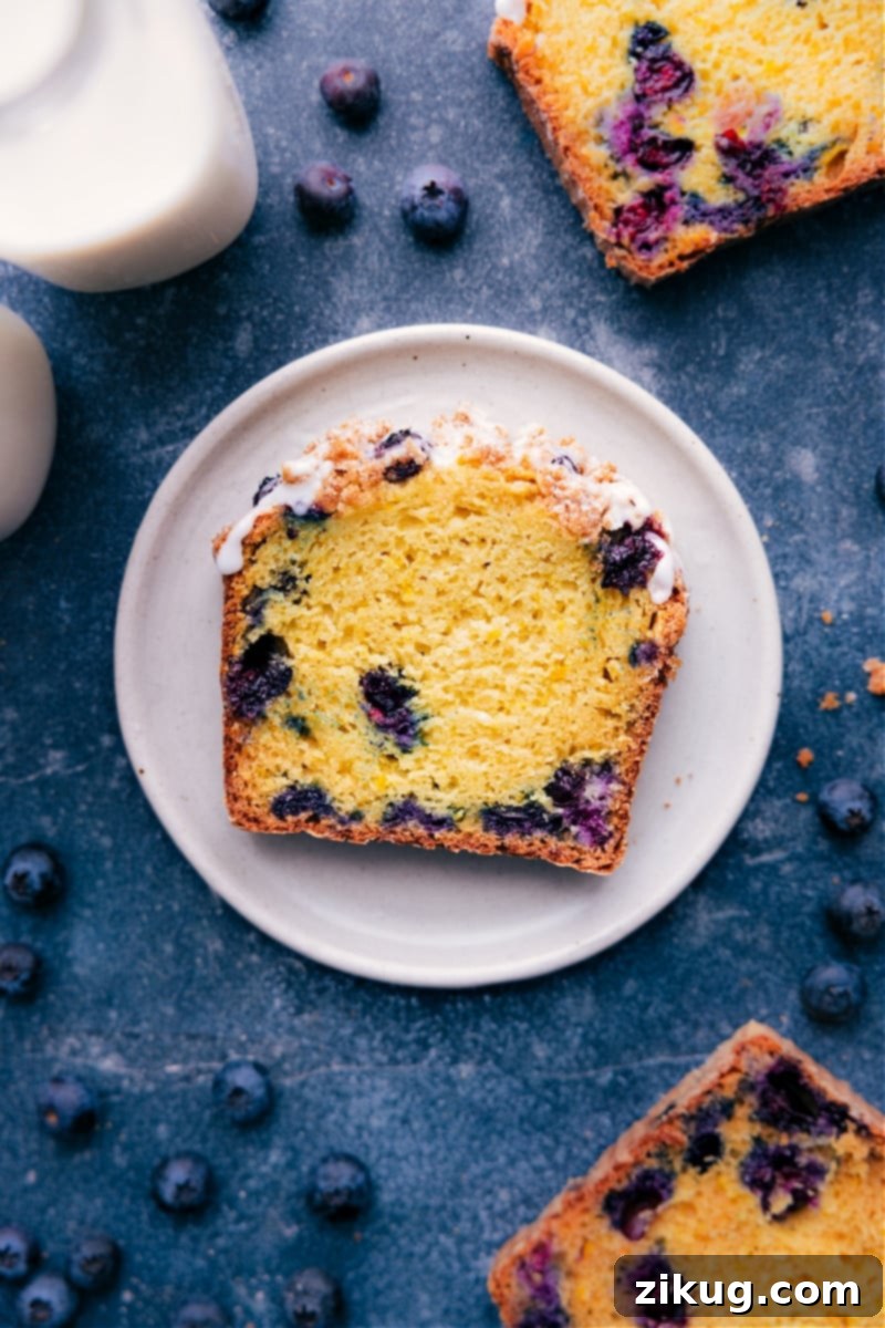 Lemon Blueberry Bread Slice - Moist and Irresistible A slice of the finished lemon blueberry bread showing its moist delicious center and topped with a sweet icing.