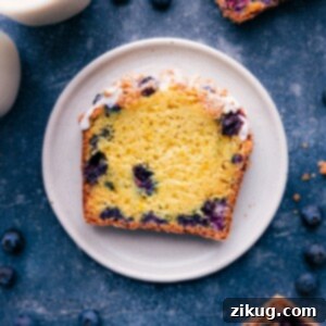 Bright Lemon Blueberry Loaf 2 A slice of the finished lemon blueberry bread showing its moist delicious center and topped with a sweet icing.