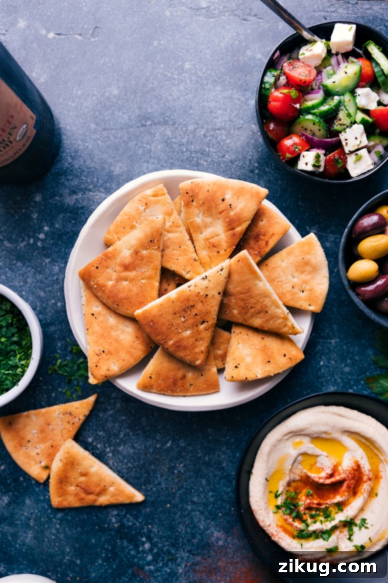 Homemade Pita Chips are out-of-this-world delicious! These big, thick, and crunchy chips are the perfect vehicle for a good dip and the ultimate addition to a fun Mediterranean spread. Recipe via chelseasmessyapron #appetizer #best #quick #easy #simple #snacks #pita #chips Overhead image of golden brown Pita Chips arranged attractively, ready for dipping.