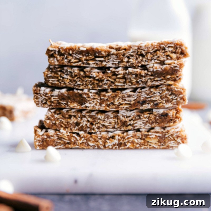 These Oatmeal Granola Bars are made to taste like an iced oatmeal cookie! Recipe via ChelseasMessyApron #quick #easy #snack #best #simple #glaze #oats #healthy #kidfriendly #oatmeal #granola #bars A stack of beautifully glazed no-bake oatmeal granola bars, ready for a healthy and delicious snack.