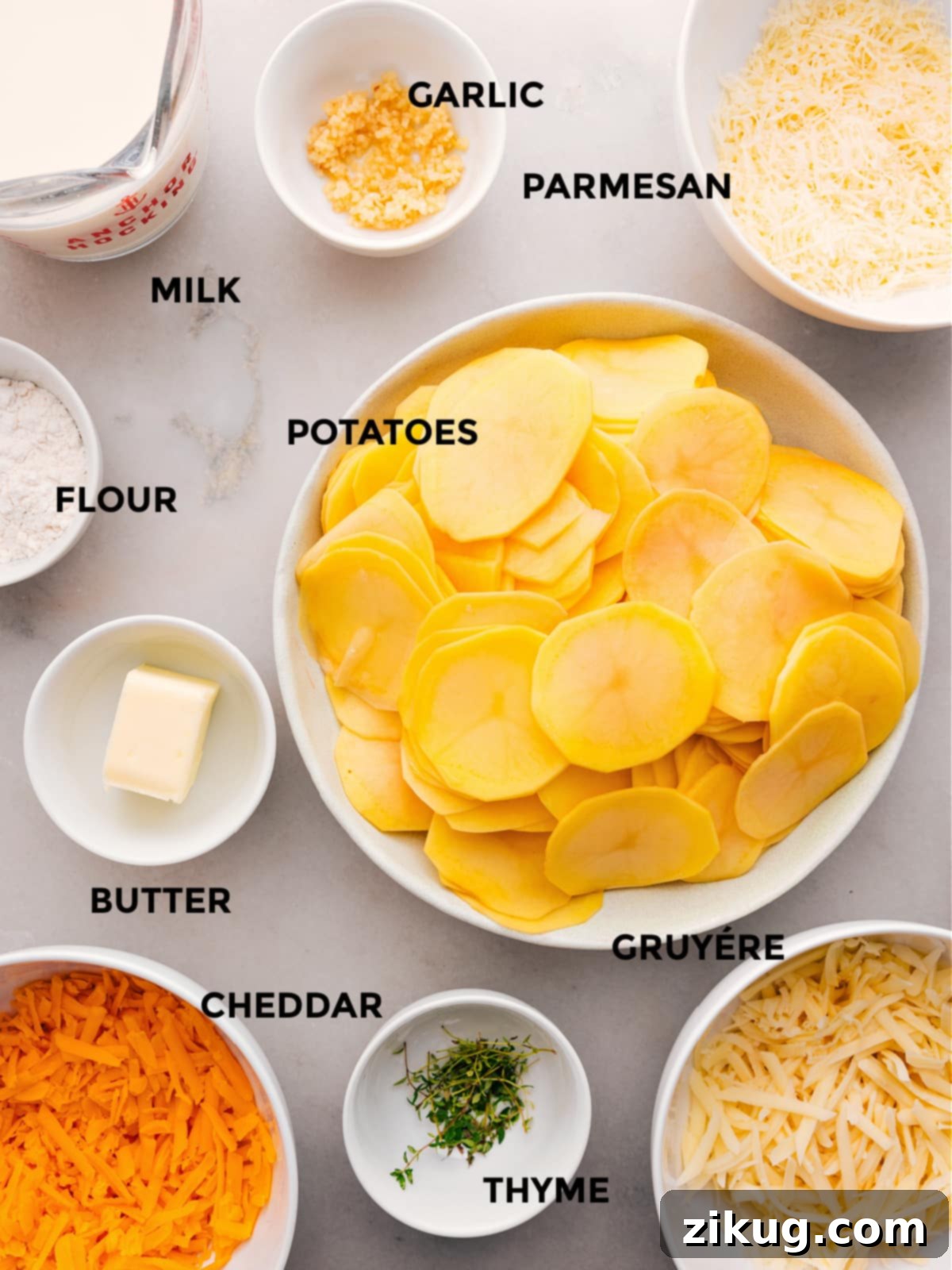 Key Ingredients For The Best Au Gratin Potatoes All the essential ingredients for Au Gratin Potatoes laid out: fresh Yukon Gold potatoes, butter, flour, whole milk, a mix of Cheddar, Gruyère, and Parmesan cheeses, minced garlic, and fresh thyme