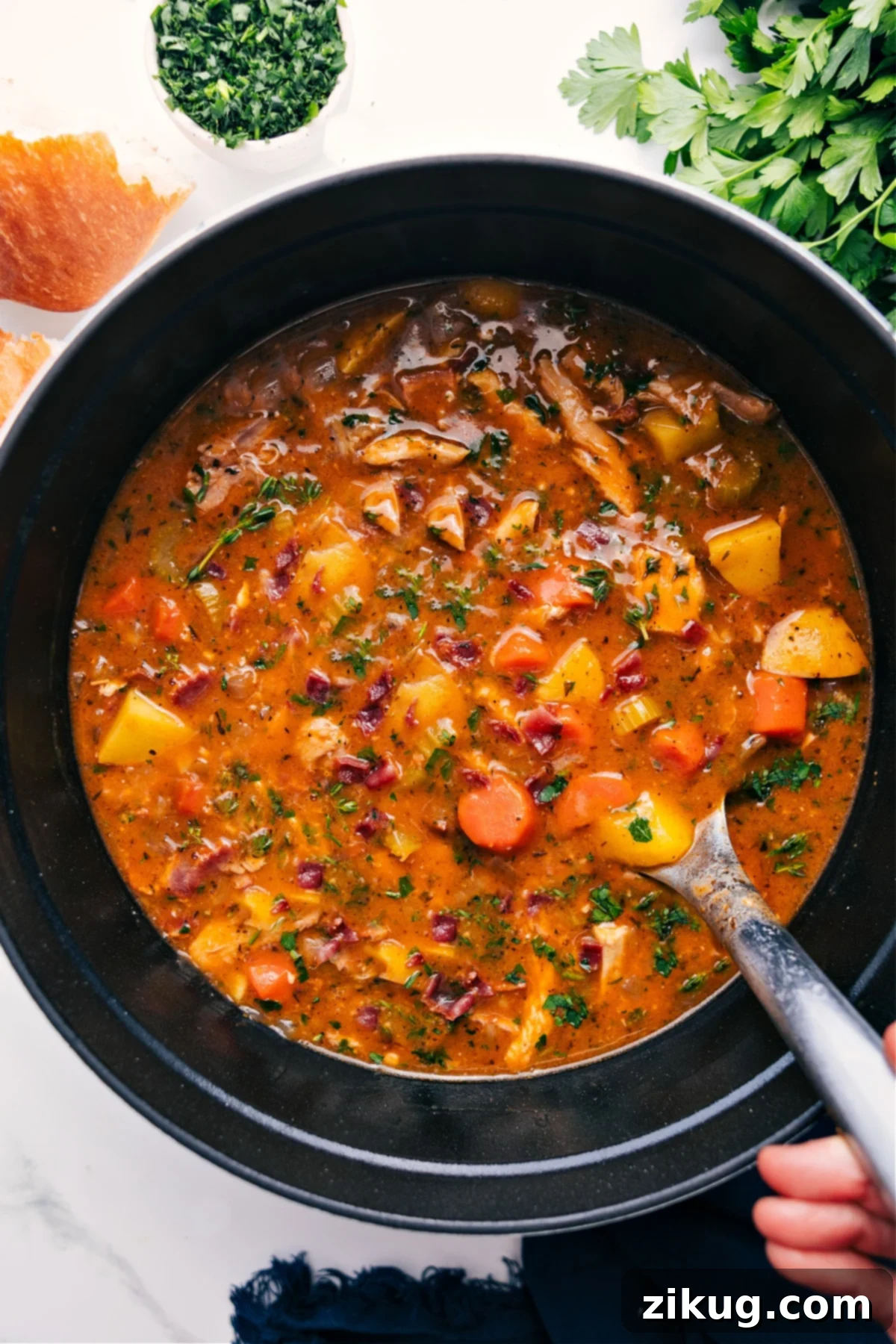 A large pot brimming with delicious Chicken Stew, featuring tender chicken pieces, vibrant vegetables, and a rich, golden broth, ready to be served and enjoyed for a comforting meal.