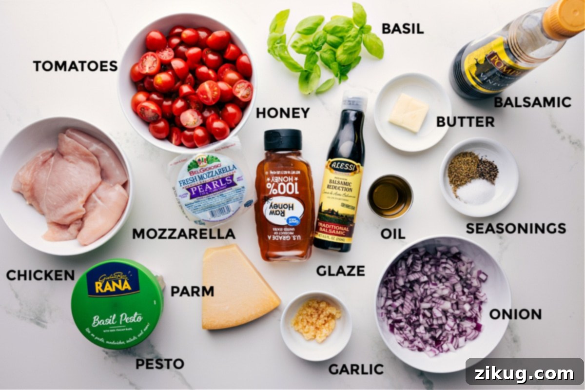 All the vibrant ingredients for this Caprese chicken recipe are prepped and beautifully arranged, including fresh basil, seasoned chicken, balsamic glaze, butter, Italian seasonings, diced red onion, olive oil, honey, minced garlic, grated Parmesan, mozzarella pearls, and ripe cherry tomatoes.