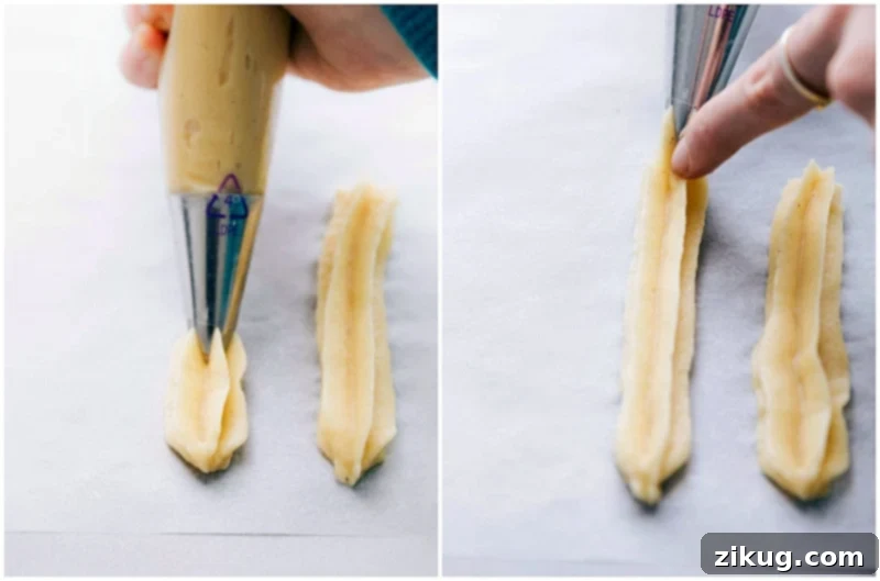 Piping Churro Dough into Perfect Ridged Shapes Churro dough being piped through a pastry bag onto a parchment-lined tray, forming long, ridged cylinders characteristic of churros, awaiting frying.