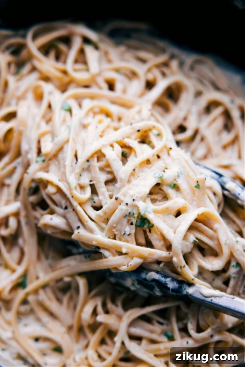 This rich and creamy Fettuccine Alfredo is one of the quickest and easiest recipes to make! This indulgent pasta recipe tastes restaurant-quality, but can be made in the comfort of your home in about 20 minutes or less! Recipe via chelseasmessyapron #dinner #quick #easy #simple #best #familyfriendly #kidfriendly #comfortfood #cheesy #fettuccine #alfredo Overhead image of Fettuccine Alfredo