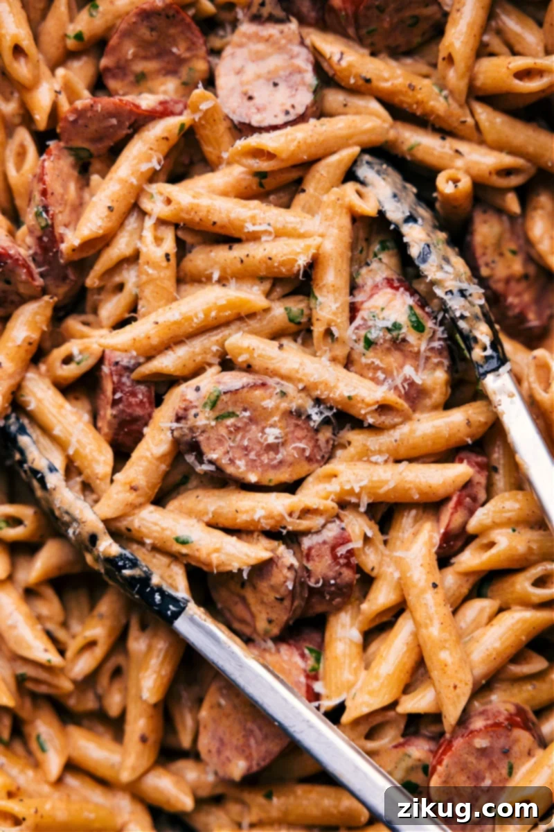 Creamy Sausage Alfredo Pasta 2 Overhead image of a beautifully plated Sausage Alfredo Pasta, showcasing penne, sliced sausage, and creamy sauce, garnished with fresh parsley.