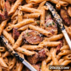 Close-up of a serving of Sausage Alfredo Pasta, garnished with fresh parsley.