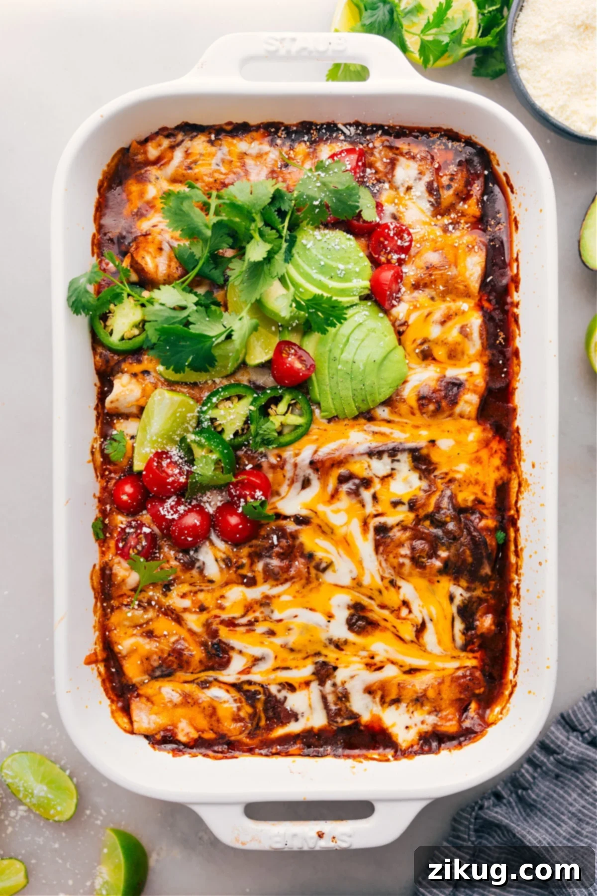 Irresistible Shredded Beef Enchiladas: Your New Favorite Dinner (Crockpot or Instant Pot) Tender Shredded Beef Enchiladas, fresh from the oven, generously topped with fresh cilantro, sour cream, and diced tomatoes, ready to be served as a hearty and flavorful meal.