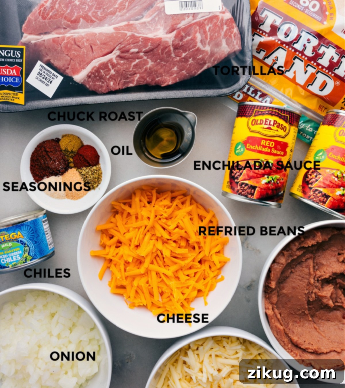 Essential Ingredients for Delicious Shredded Beef Enchiladas A vibrant display of all the essential ingredients for making Shredded Beef Enchiladas, meticulously prepped and arranged for seamless assembly. This includes succulent shredded beef, soft flour tortillas, a rich red enchilada sauce, creamy refried beans, two types of freshly grated cheese, aromatic seasonings, and a can of mild green chiles.