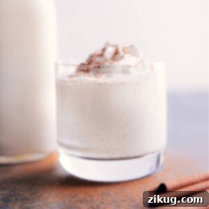 Homemade Holiday Eggnog 2 A cup of creamy homemade eggnog garnished with a cinnamon stick and a sprinkle of nutmeg.