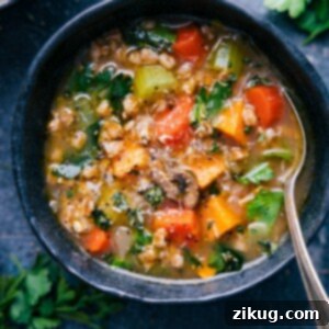 A rustic bowl filled with steaming Farro Soup, topped with fresh herbs and a hint of cheese.