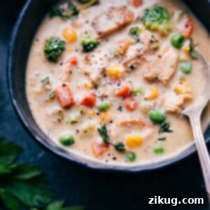 A bowl of rich and creamy chicken soup with vegetables, ready to be enjoyed.