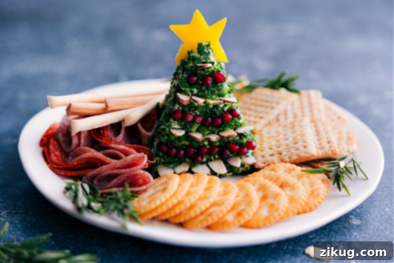 A festive Christmas Tree Cheeseball, beautifully decorated with almonds and pomegranate, ready to be enjoyed on a serving plate.