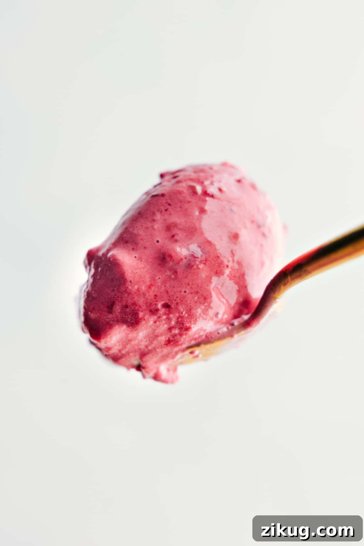 A big spoonful of the creamy, homemade frozen yogurt, showcasing its smooth texture.