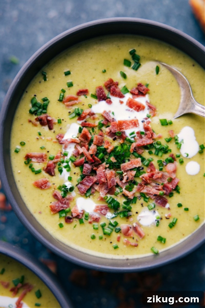 Overhead image of a bowl of creamy, cheesy Broccoli Soup garnished with fresh parsley.