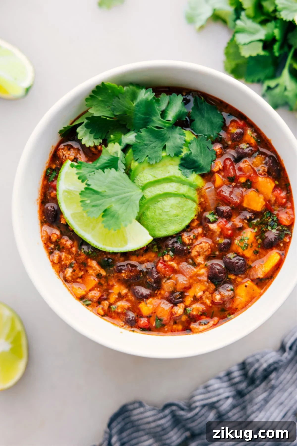 A vibrant bowl of Beef Enchilada Soup, garnished with fresh cilantro and a dollop of sour cream, ready to be enjoyed.