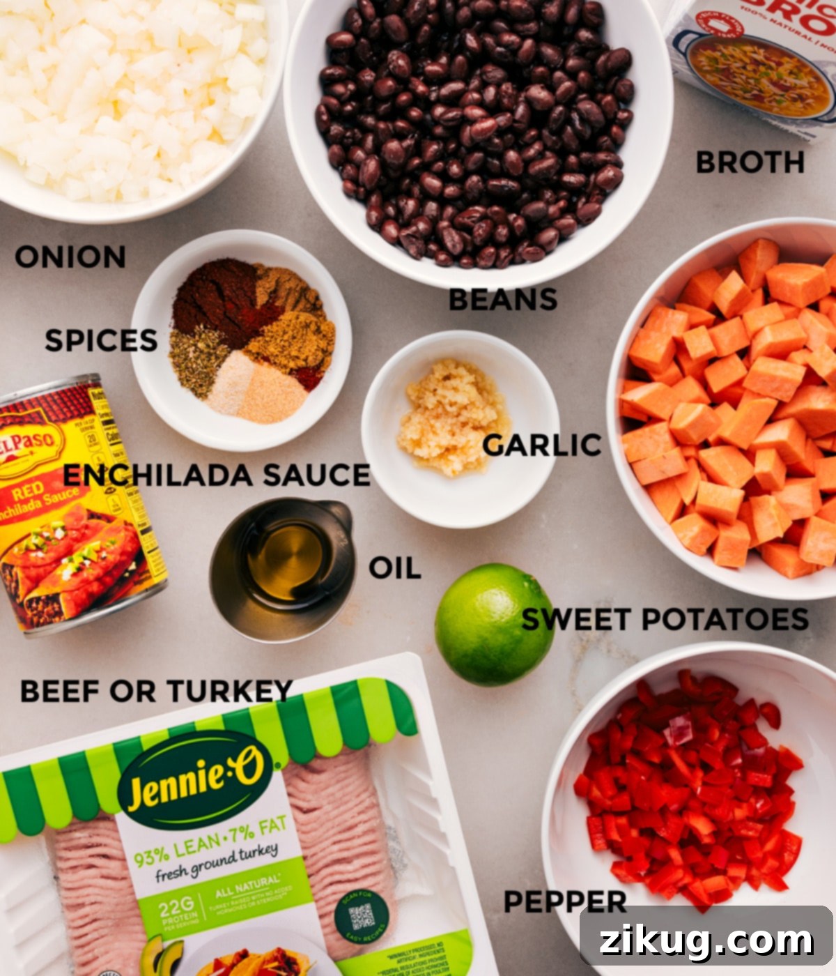 All the fresh ingredients laid out: diced onion, red bell pepper, sweet potatoes, lean ground meat, garlic, spices, a can of red enchilada sauce, black beans, and chicken broth, ready for assembly.