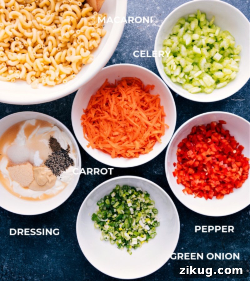 Collection of fresh ingredients for Macaroni Salad including pasta, vegetables, and dressing components.