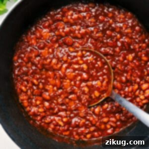 A close-up shot of the savory baked beans, showcasing their rich, thick sauce and tender beans.