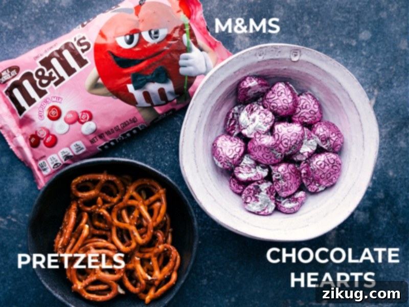 A view of the ingredients required for this recipe, showcasing pretzels, Dove chocolate hearts, and red M&M's.