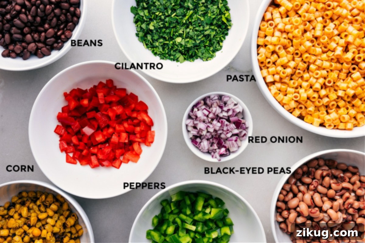 Fresh Ingredients In Cowboy Caviar Pasta Salad All the vibrant ingredients for Cowboy Caviar Pasta Salad prepped and ready for assembly, including cooked ditalini pasta, black beans, black-eyed peas, cilantro, red onions, and colorful bell peppers.