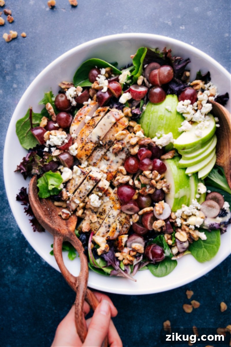 Delicious Honey Mustard Vinaigrette on a fresh salad Overhead view of a dinner salad with Honey Mustard Vinaigrette drizzled generously over fresh greens, grilled chicken, and various colorful vegetables.