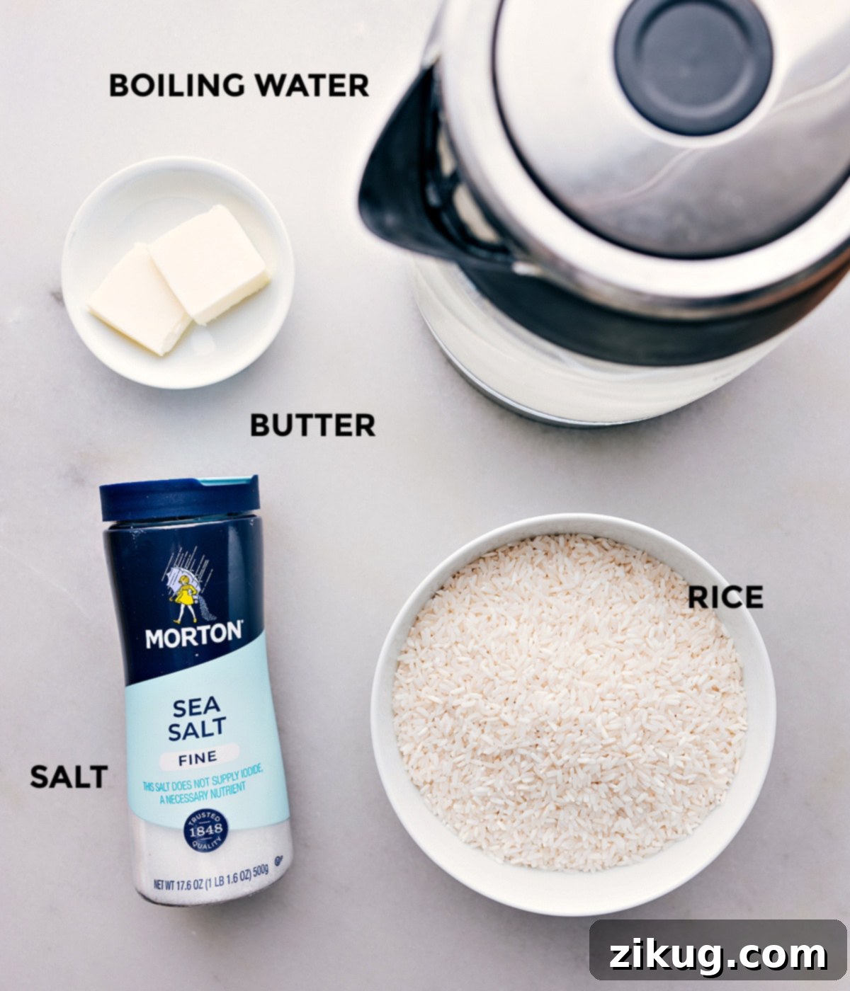 Collection of essential ingredients for making oven-baked white rice: basmati rice, salt, unsalted butter, and a pot of boiling water, arranged for clarity
