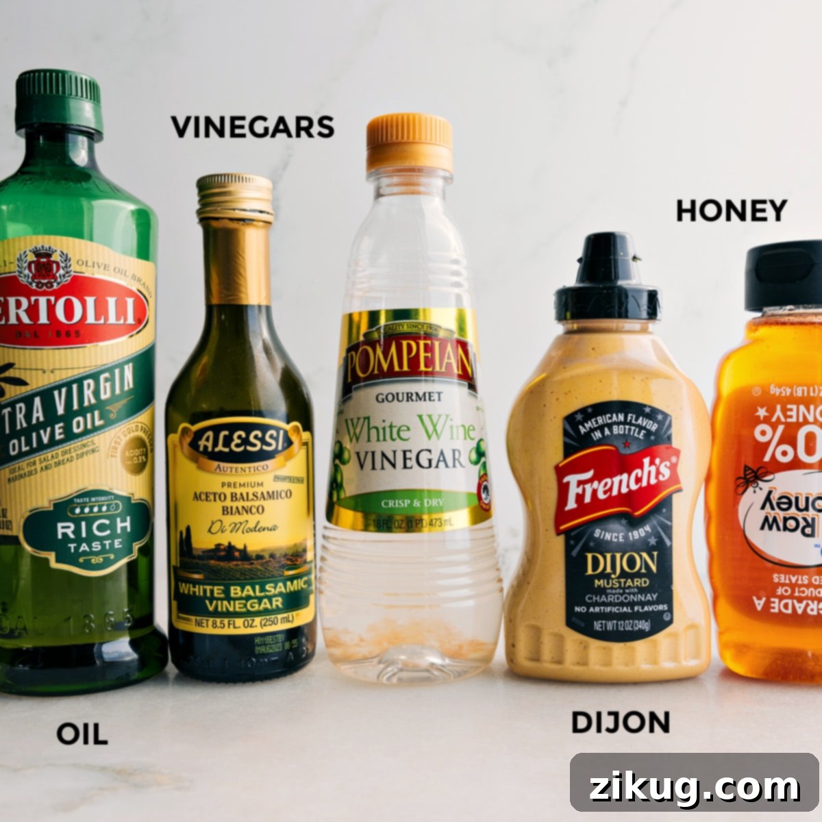 All the essential ingredients for White Balsamic Vinaigrette — premium olive oil, white balsamic vinegar, white wine vinegar, Dijon mustard, and golden honey — neatly prepped and awaiting their fusion.