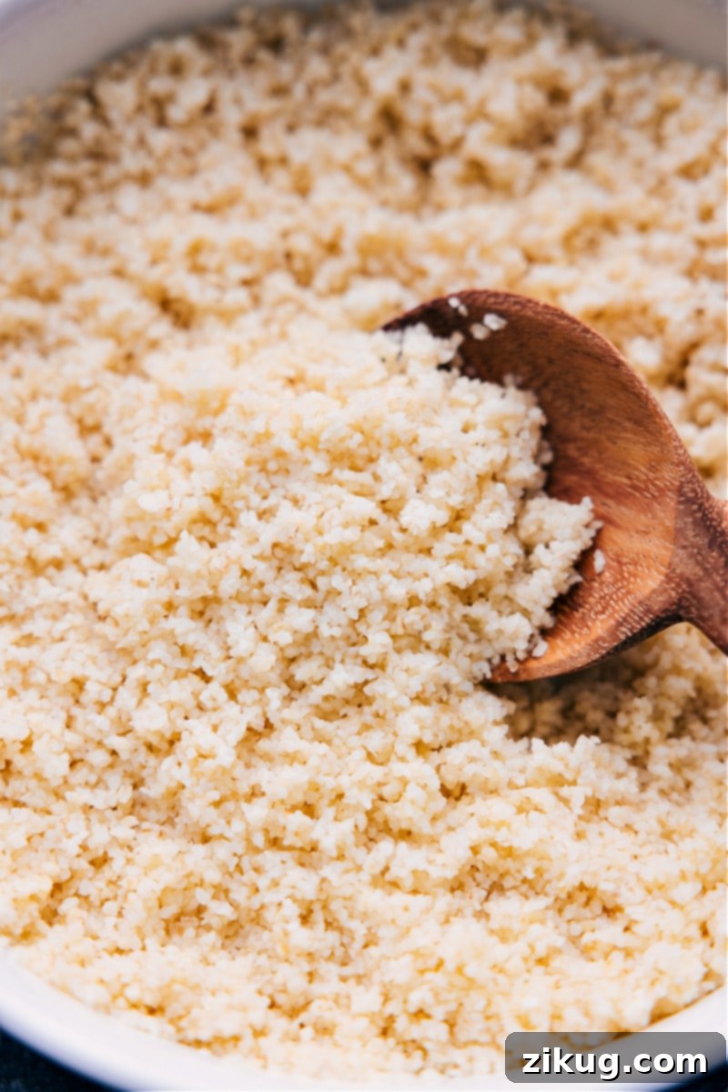 Discover the secret to perfectly fluffy and flavorful bulgur in this guide for How To Cook Bulgur Wheat! Say goodbye to bland and mushy side dishes, and hello to delicious and nutritious. Up-close overhead image of the How to Cook Bulgur Wheat recipe ready to be served in a bowl, showing fluffy grains and a garnish of fresh herbs